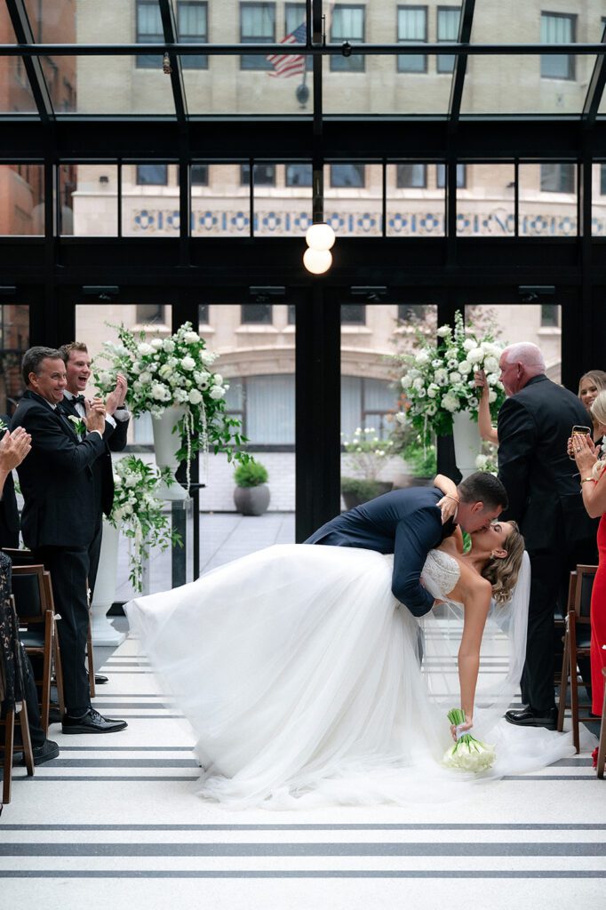 Bride and grooms kiss during their Shinola Hotel wedding ceremony in The Birdy Room