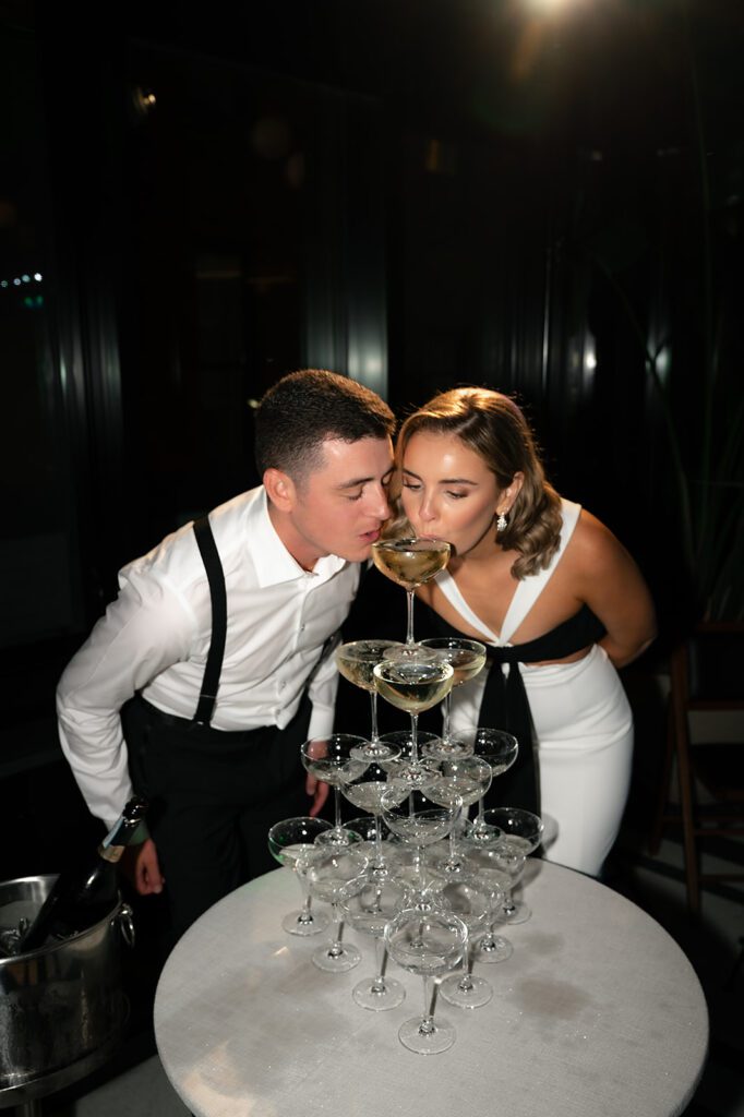 Bride and groom drinking from their champagne tower
