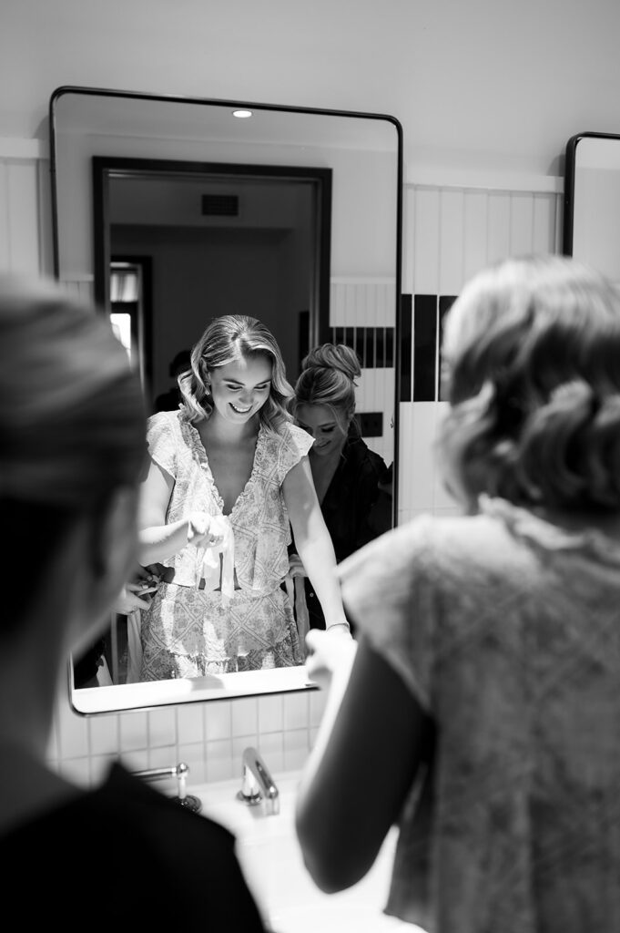 Black and white photo of a bride getting ready with her bridesmaids