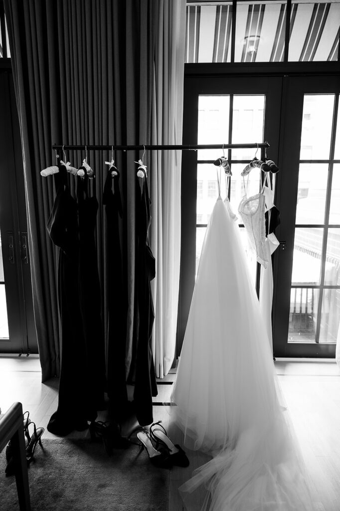 Brides dress hanging next to the bridesmaids dresses