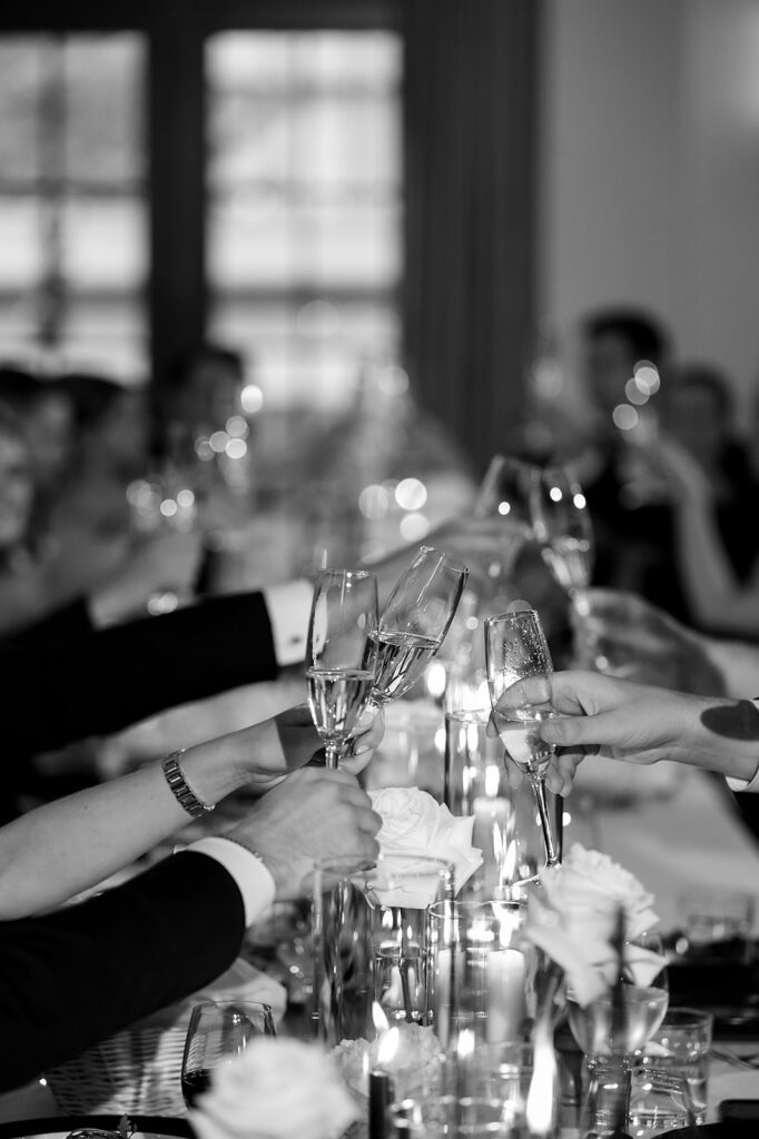 Candid wedding reception photo of guests toasting their drinks