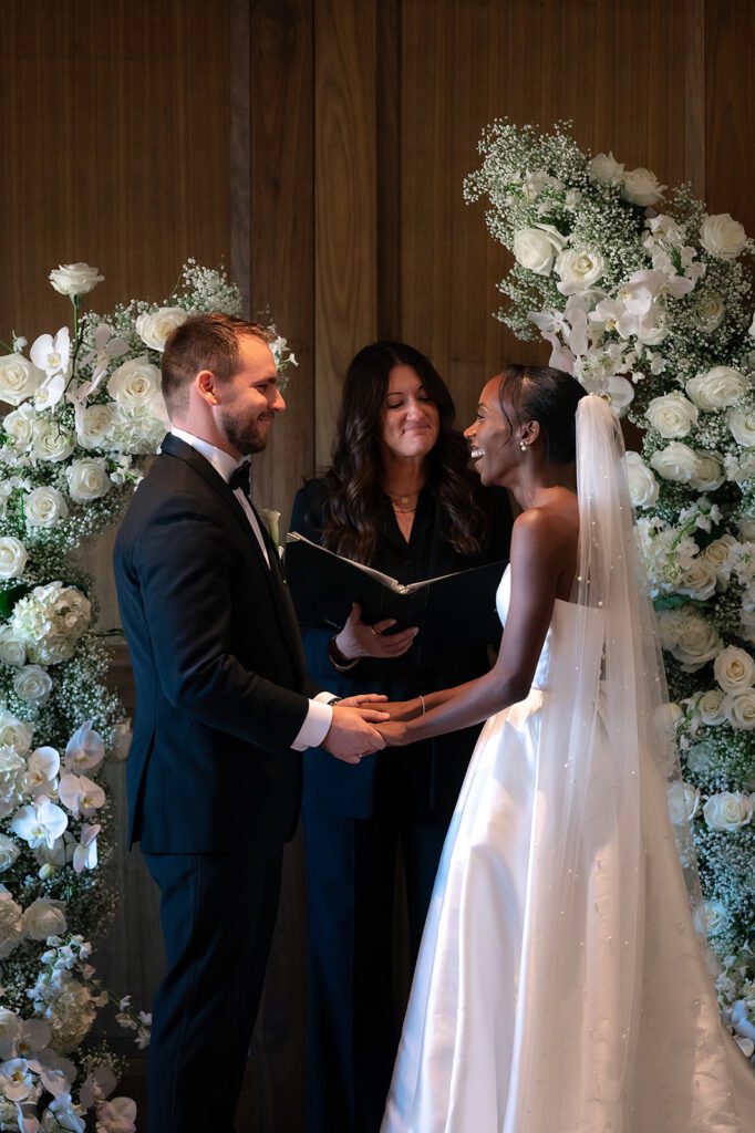 Bride and groom holding hands during their Book Tower wedding ceremony in The Linden Room