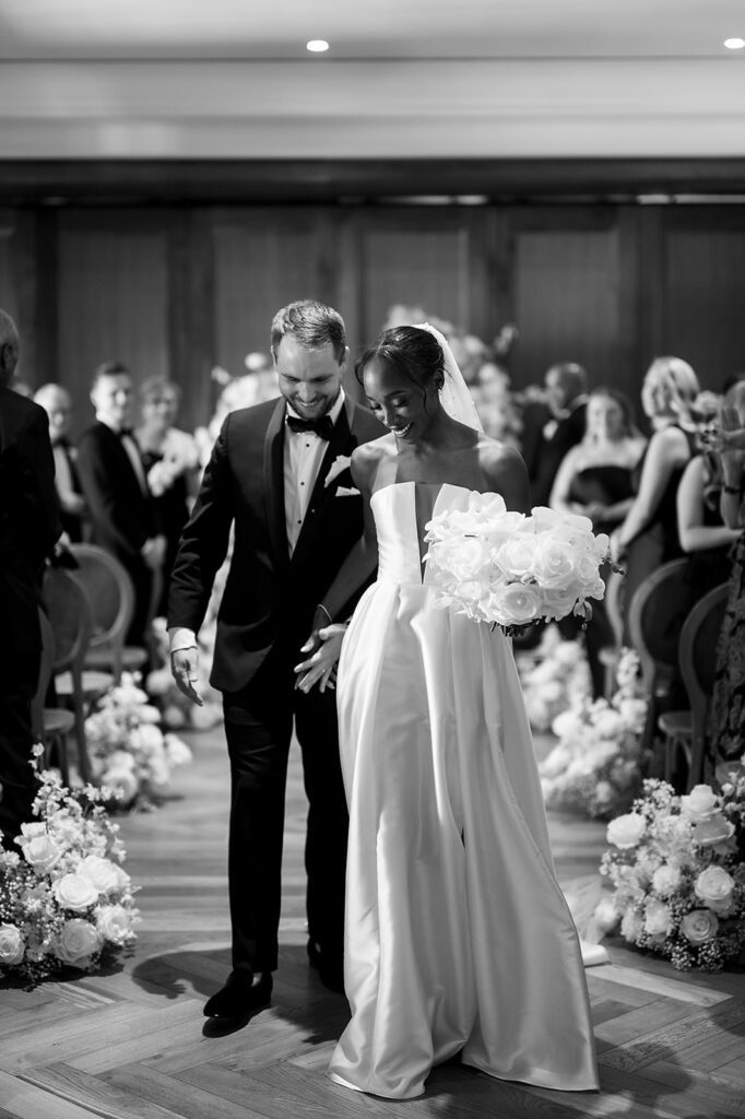 Bride and groom walking back down the aisle as husband and wife adter their Book Tower wedding ceremony