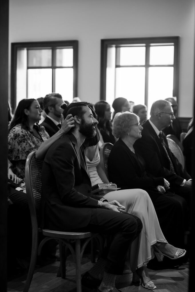 Candid wedding photo of guests sitting during the ceremony