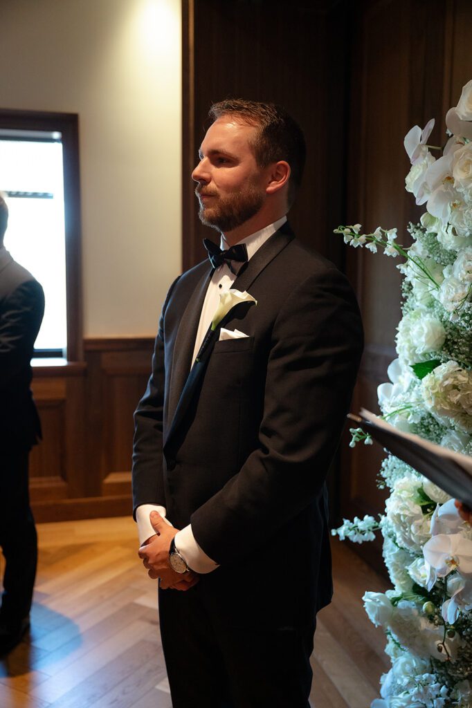 Groom watching his bride walk down the aisle