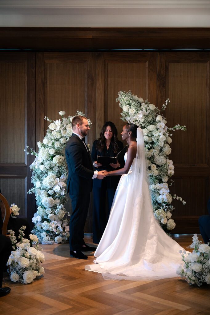 Bride and groom holding hands during their Book Tower wedding ceremony in The Linden Room