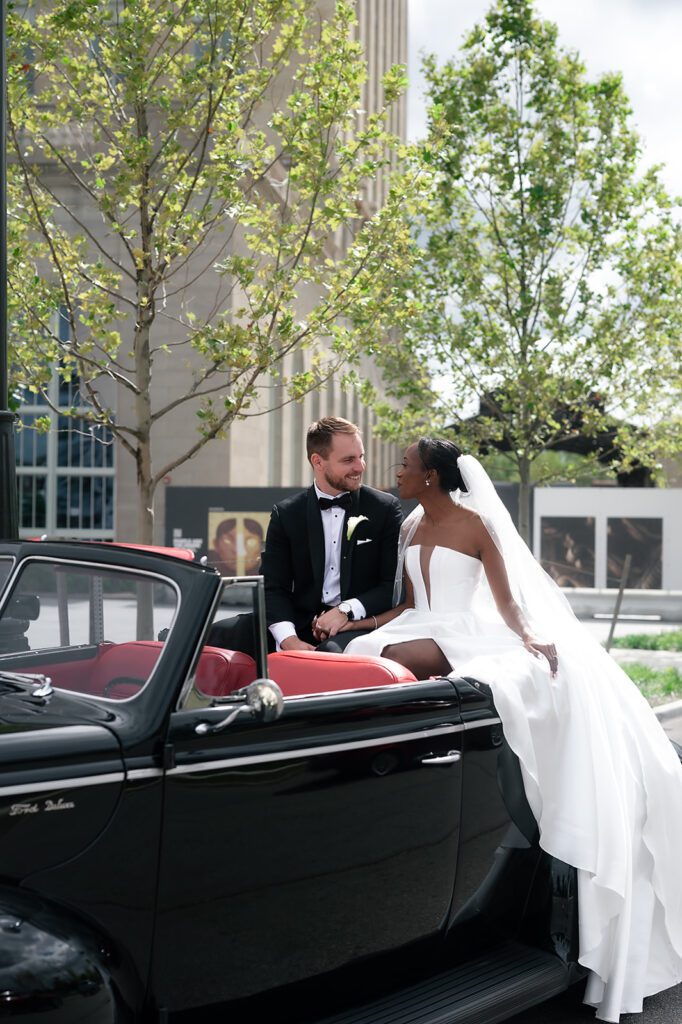 Bride and grooms Book Tower wedding portraits with a 1940 Ford Deluxe convertible from Motor City Vintage Rentals.