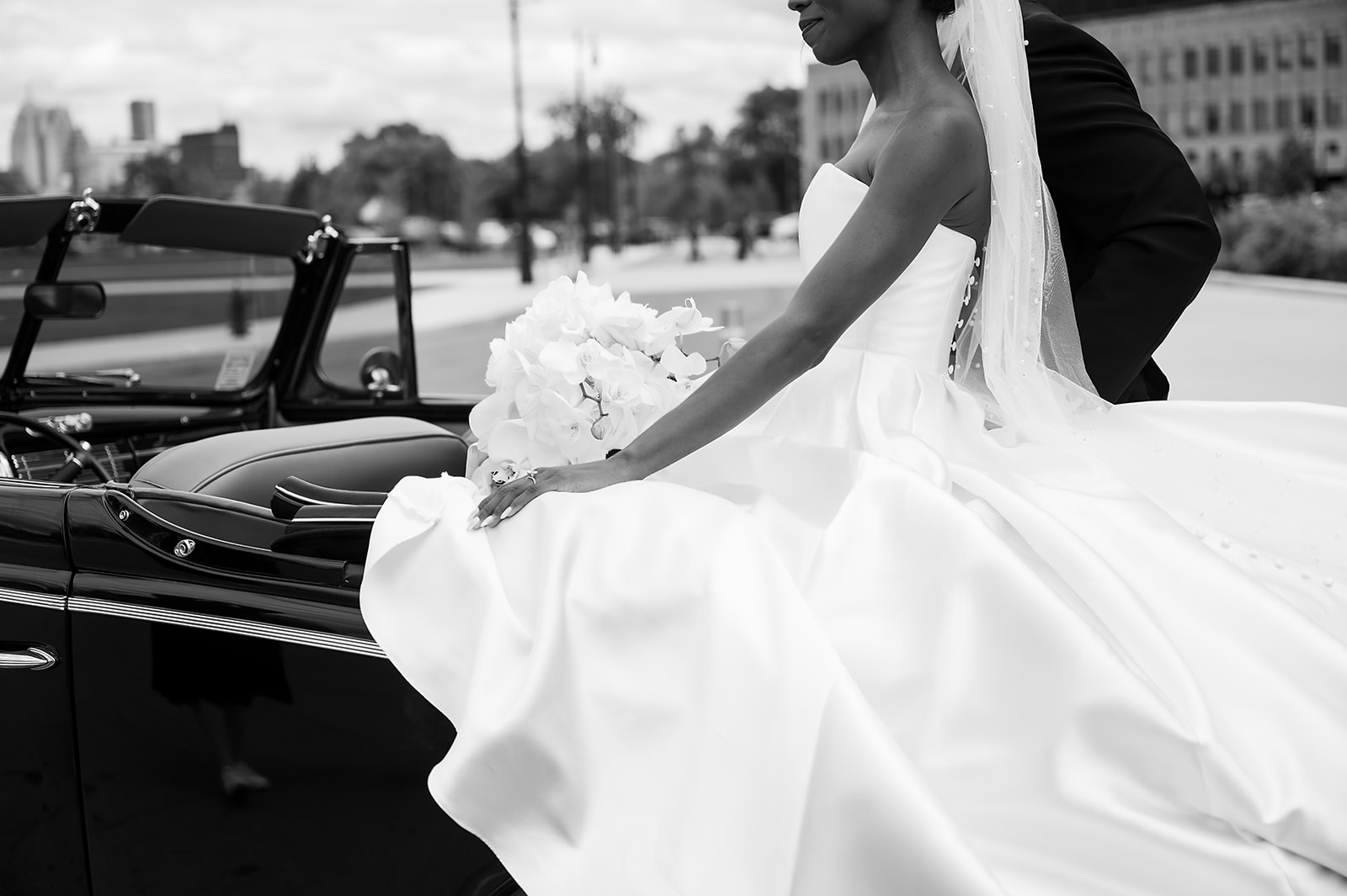 Bride and grooms Book Tower wedding portraits with a 1940 Ford Deluxe convertible from Motor City Vintage Rentals.