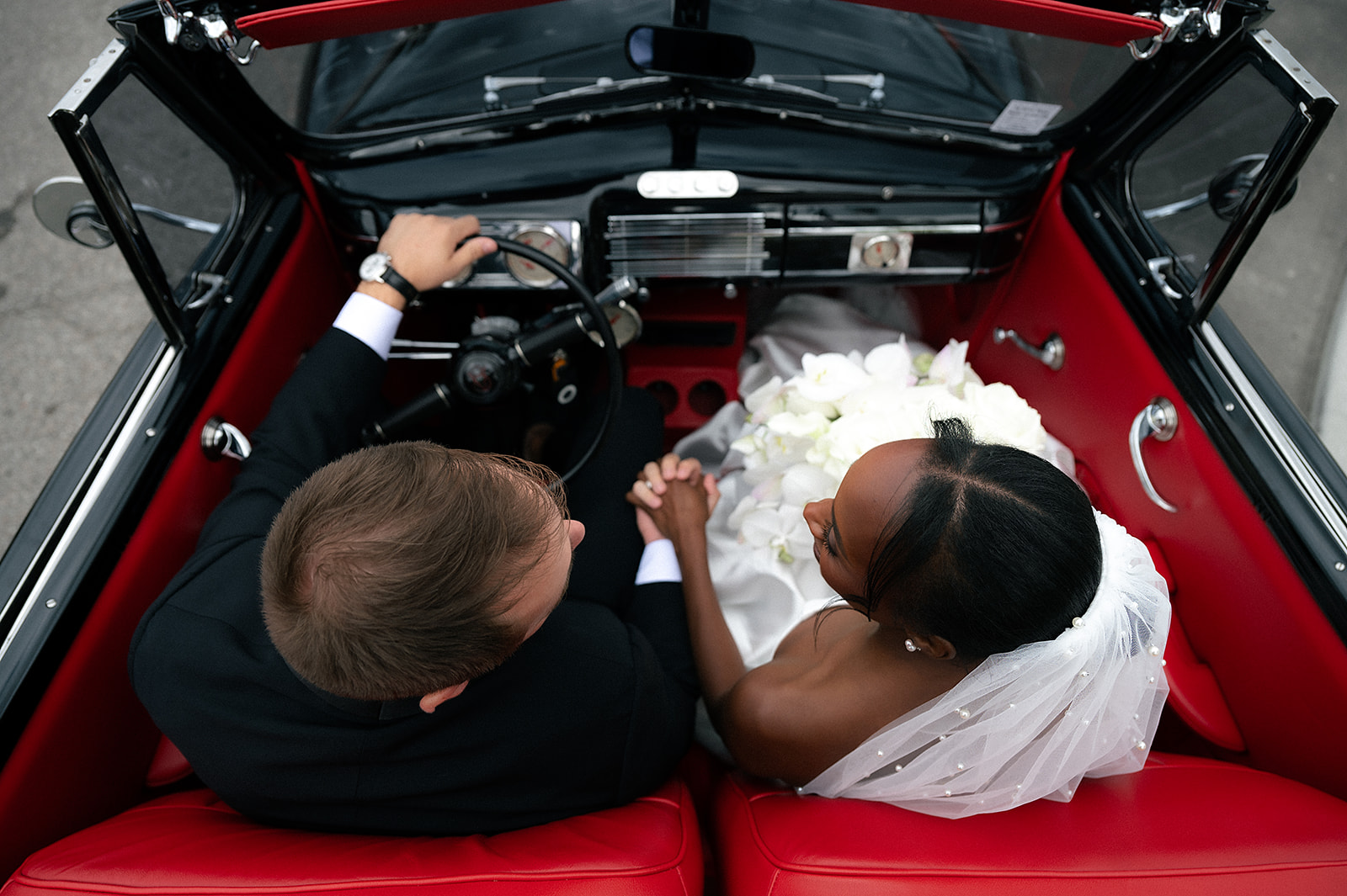 Overhead shot of a bride and groom in a classic car for their Detroit wedding portraits