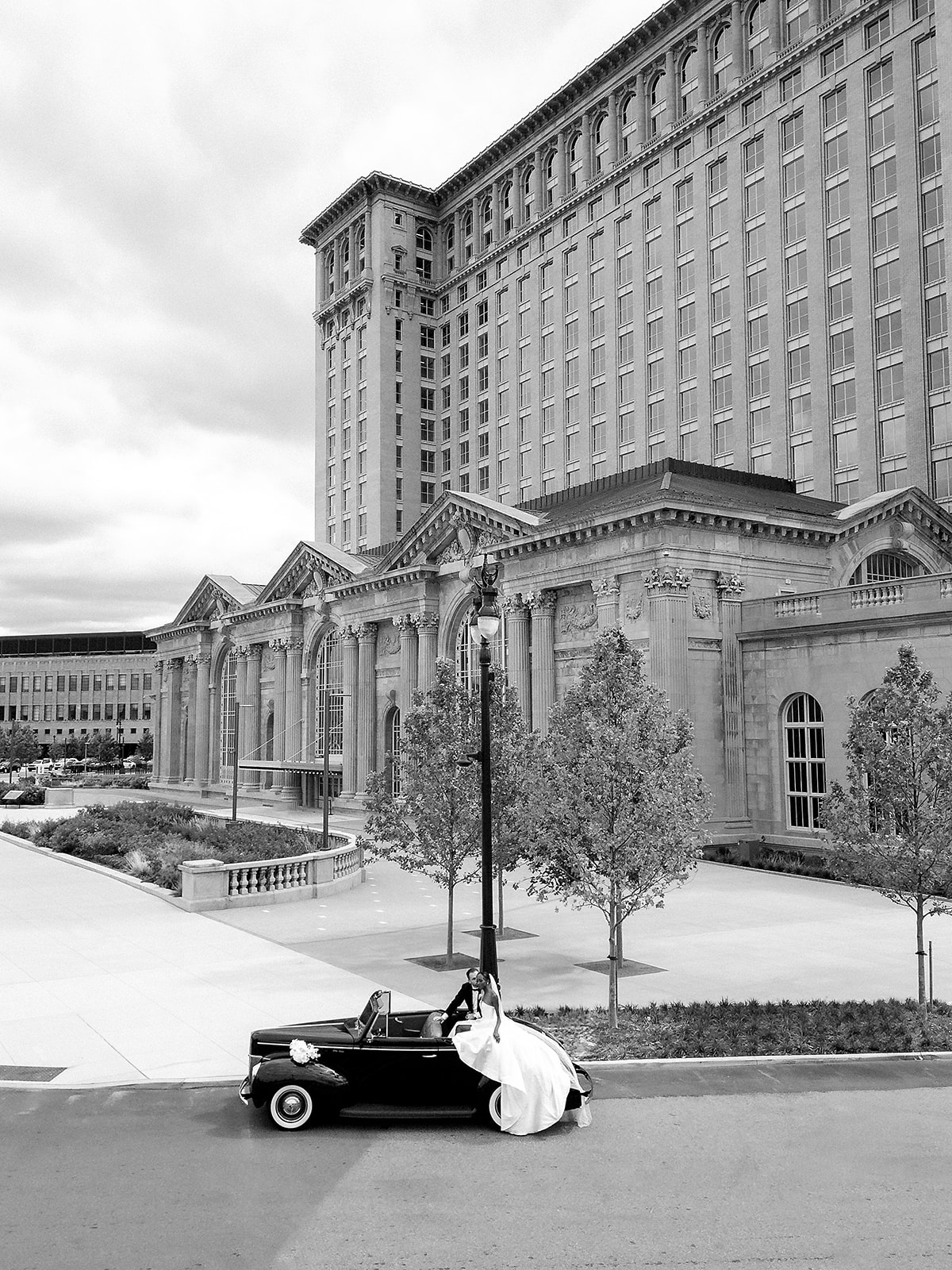 Bride and grooms Book Tower wedding portraits with a 1940 Ford Deluxe convertible from Motor City Vintage Rentals.