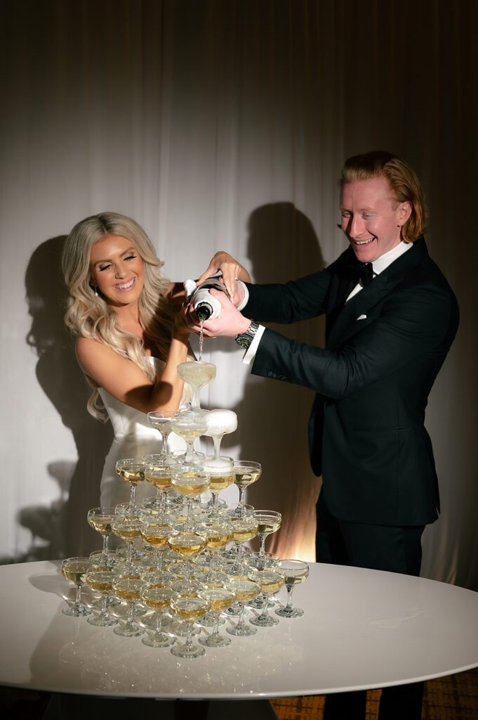 Bride and groom pouring champagne into their champagne tower