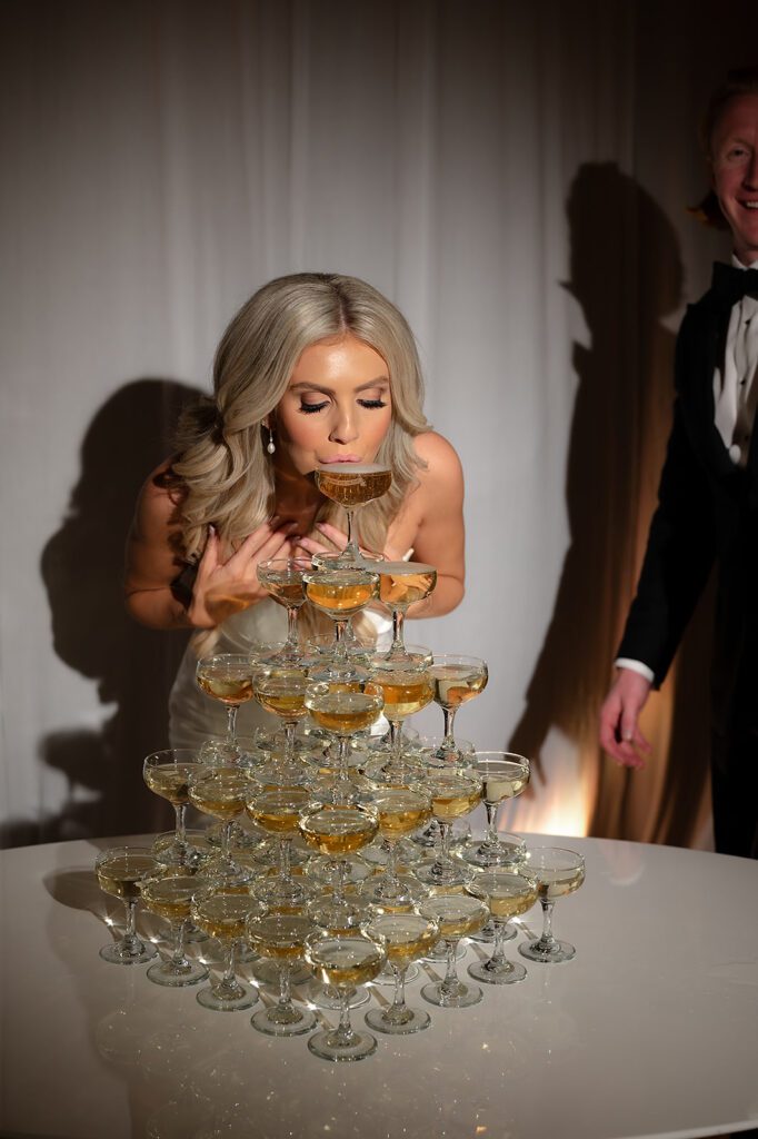 Bride sipping from their champagne tower