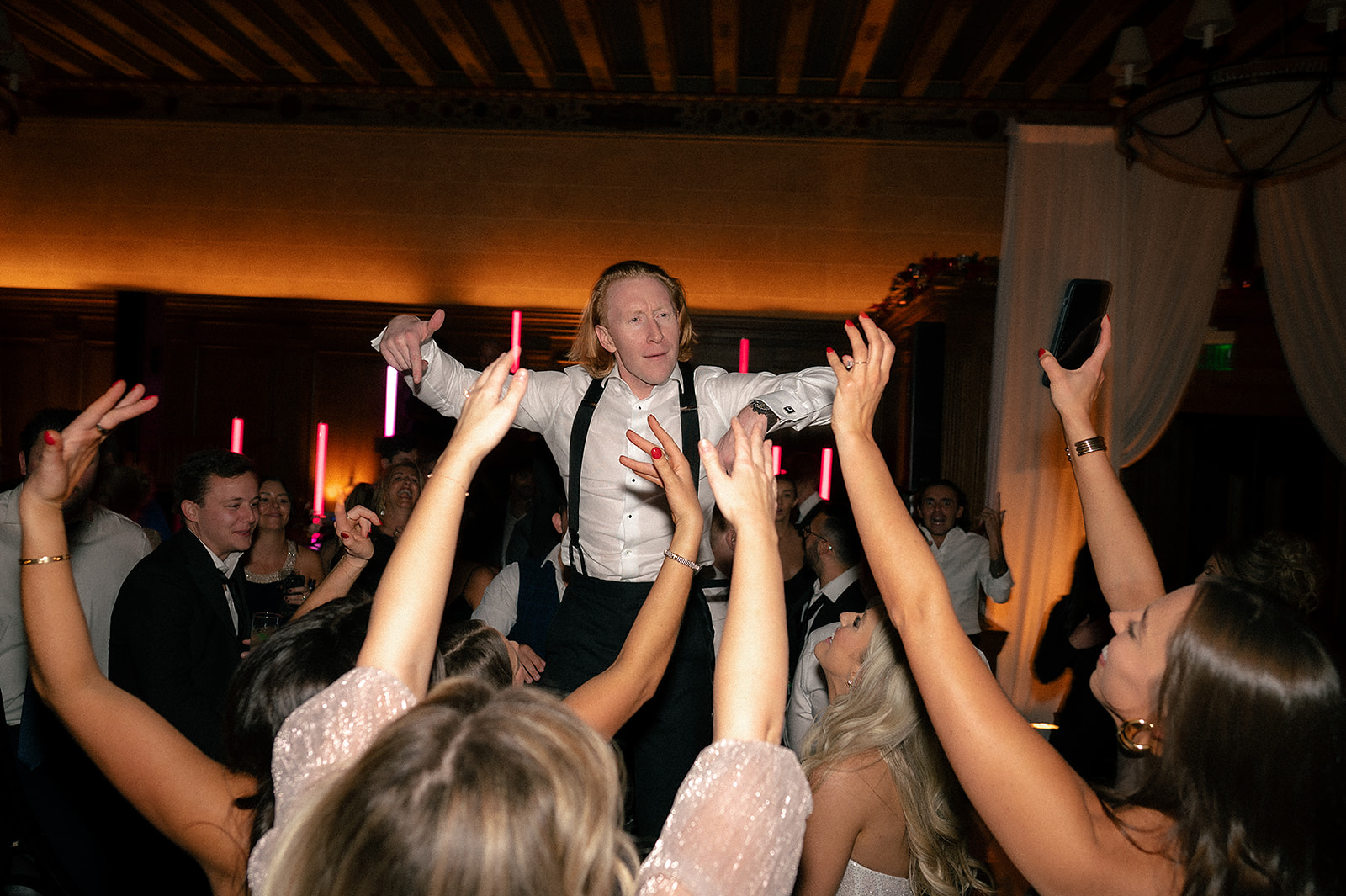 Groom being lifted in the air during his reception