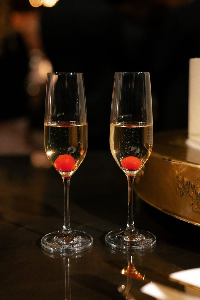 Bride and grooms champagne glasses with cherries