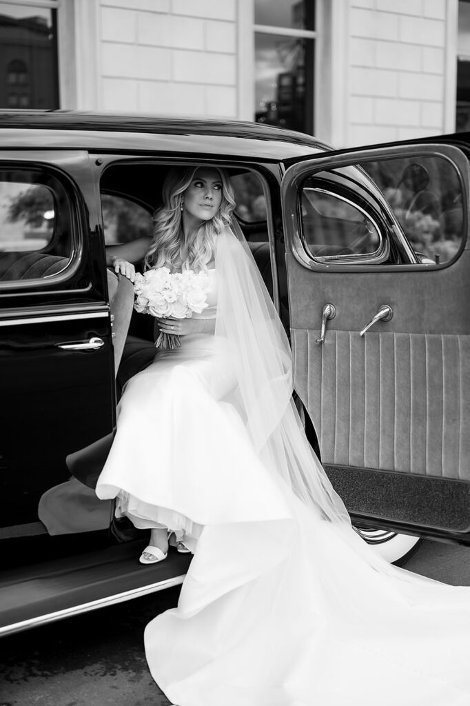 Bride posing inside of a 1940 Detroit Packard