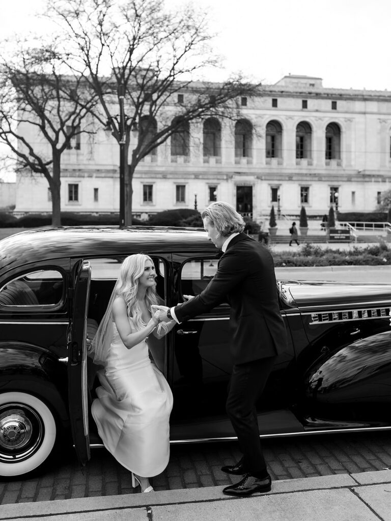 Groom helping his bride out of their 1940 Detroit Packard