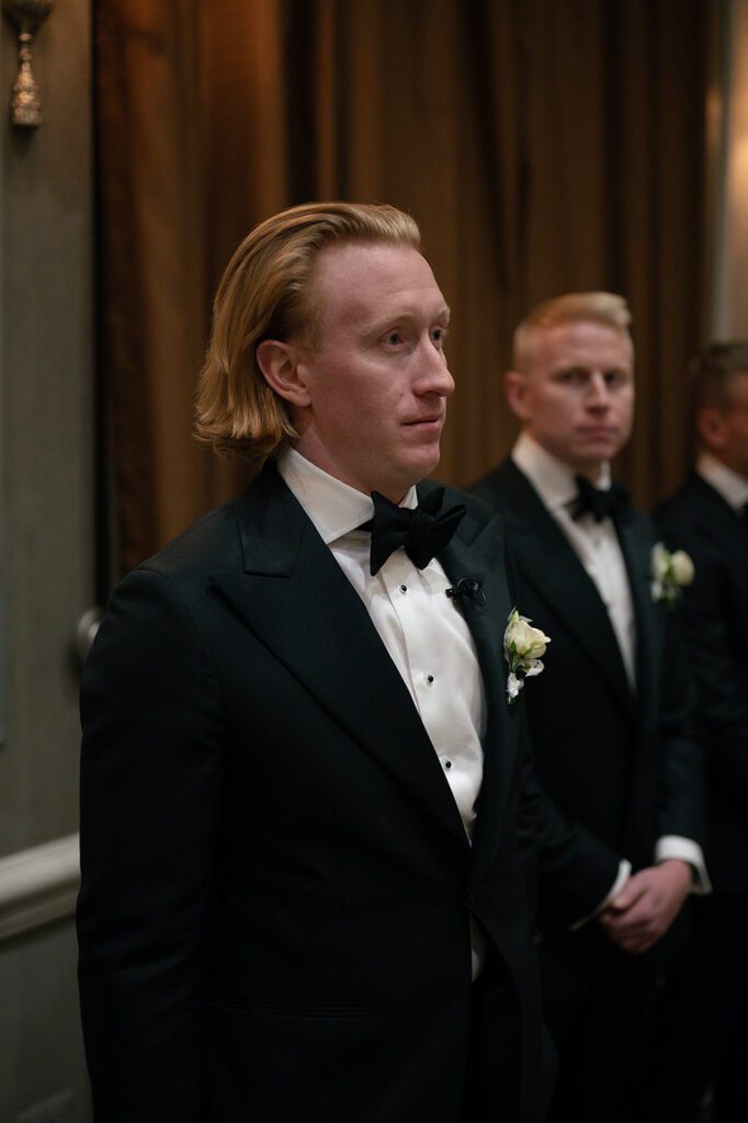 Groom watching his bride walk down the aisle