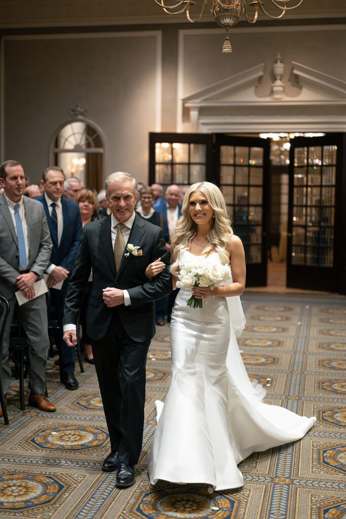 Bride walking down the aisle arm in arm with her father