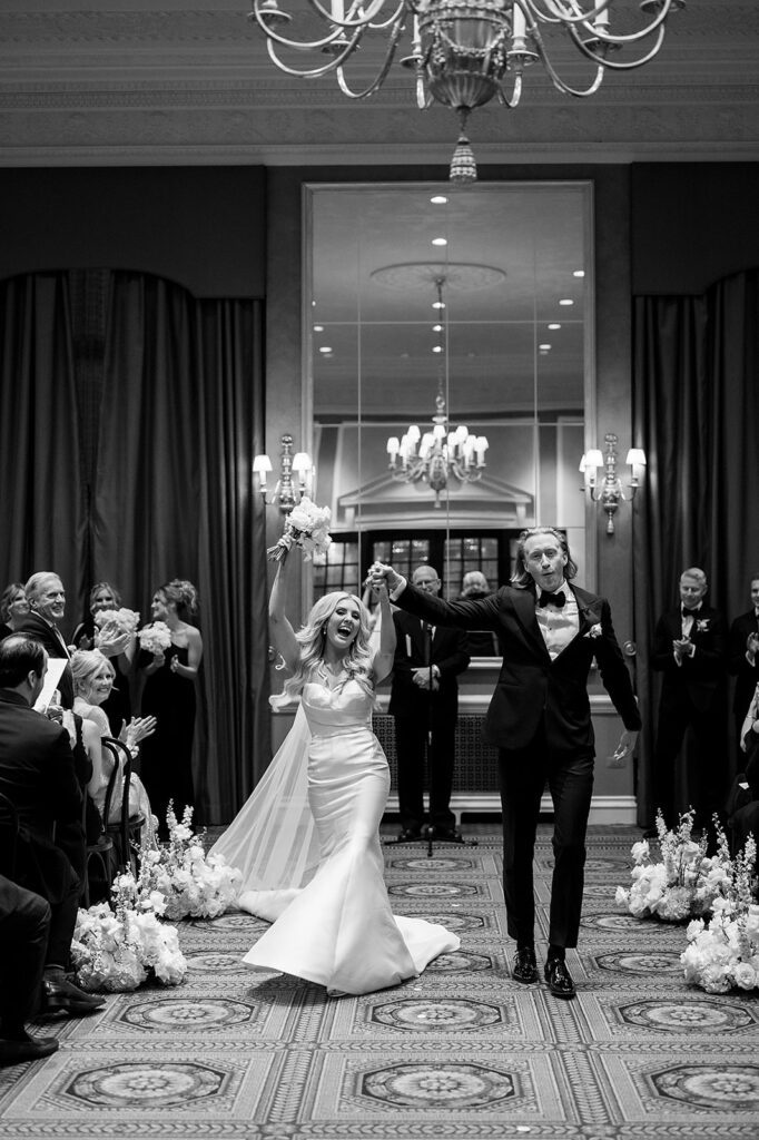 Bride and groom walking back down the aisle as husband and wife after their Detroit Athletic Club wedding ceremony