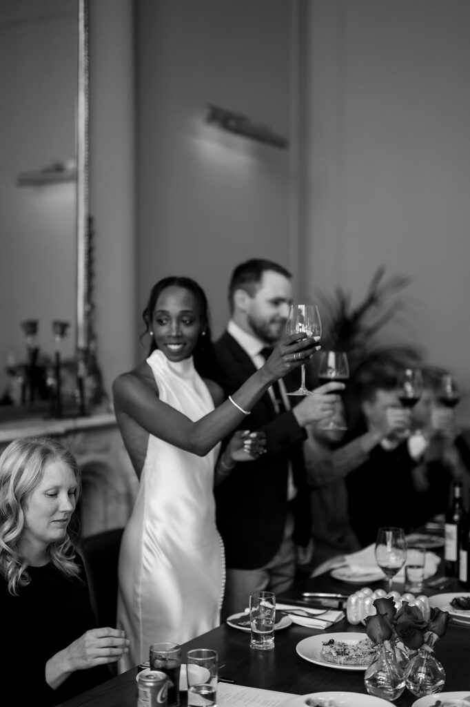 Bride and groom toasting during their intimate rehearsal dinner at Le Suprême in Detroit, Michigan