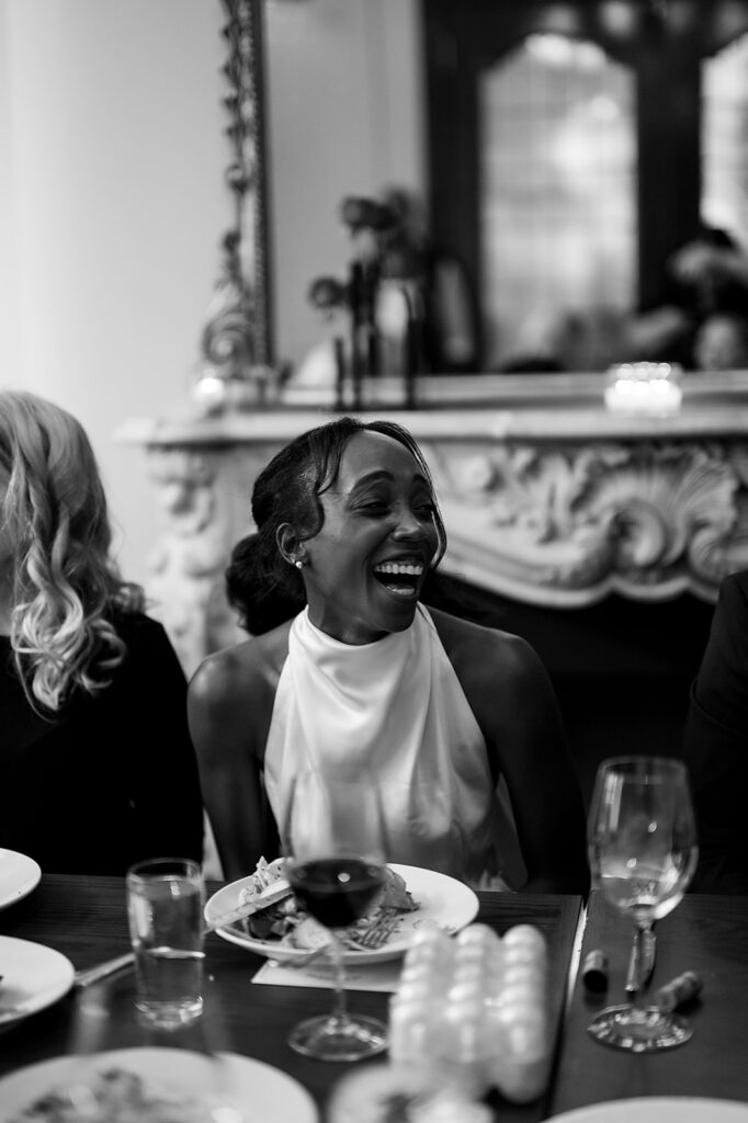 Candid wedding photo of a bride laughing during her intimate rehearsal dinner at Le Suprême in Detroit, Michigan