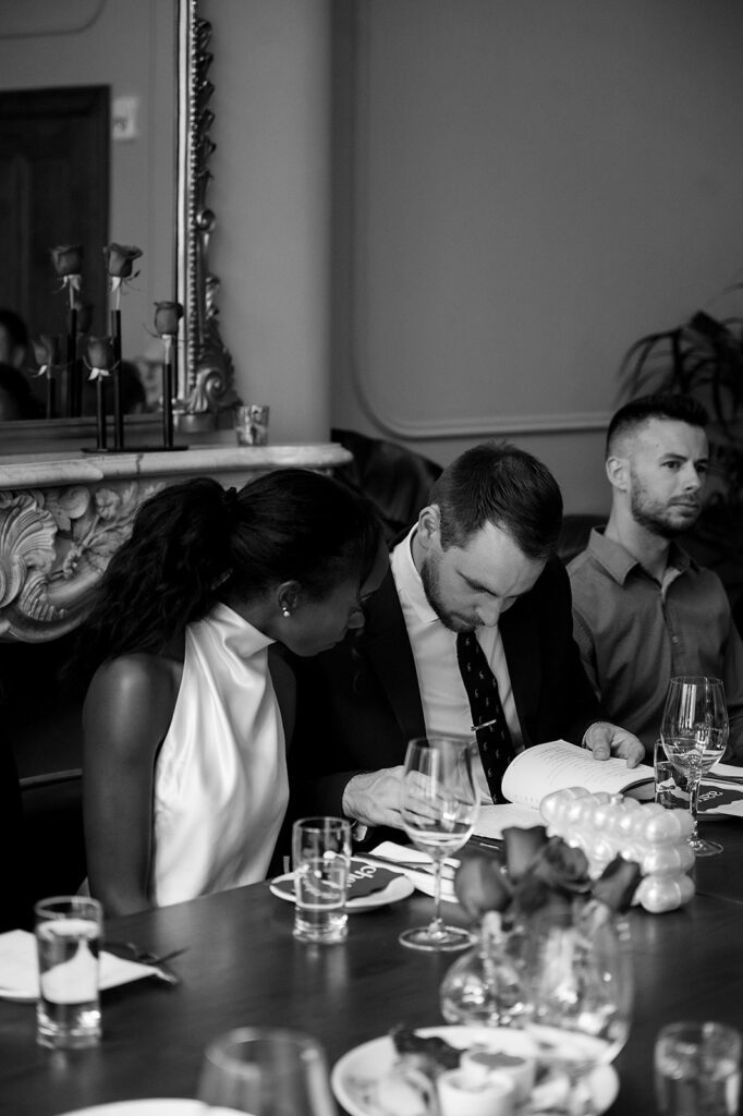 Bride and groom looking over the menu during their intimate rehearsal dinner at Le Suprême in Detroit, Michigan