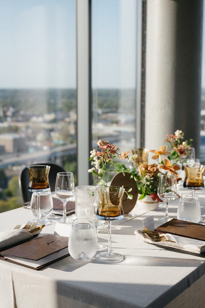 Close-up of the romantic and stylish tablescape at an MDRD Grand Plaza wedding, with amber glassware and floral centerpieces.