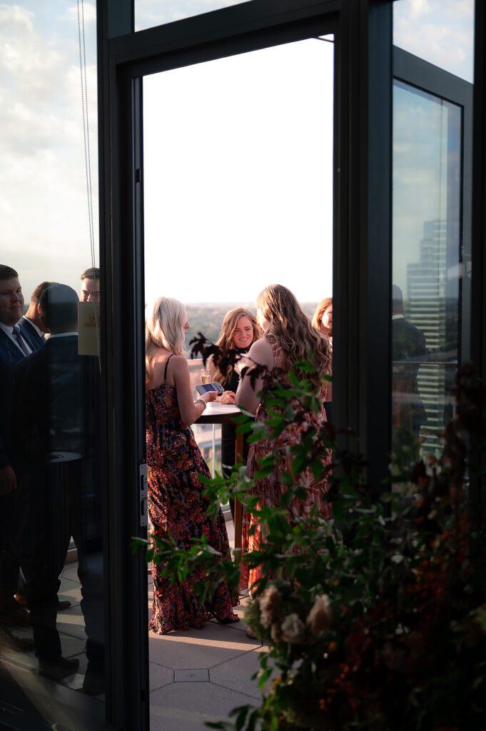 Guests enjoying golden hour cocktails on the terrace during a rooftop cocktail hour at an MDRD Grand Plaza wedding.