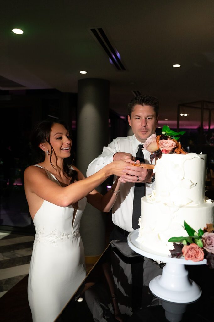 Bride and groom cutting into their wedding cake