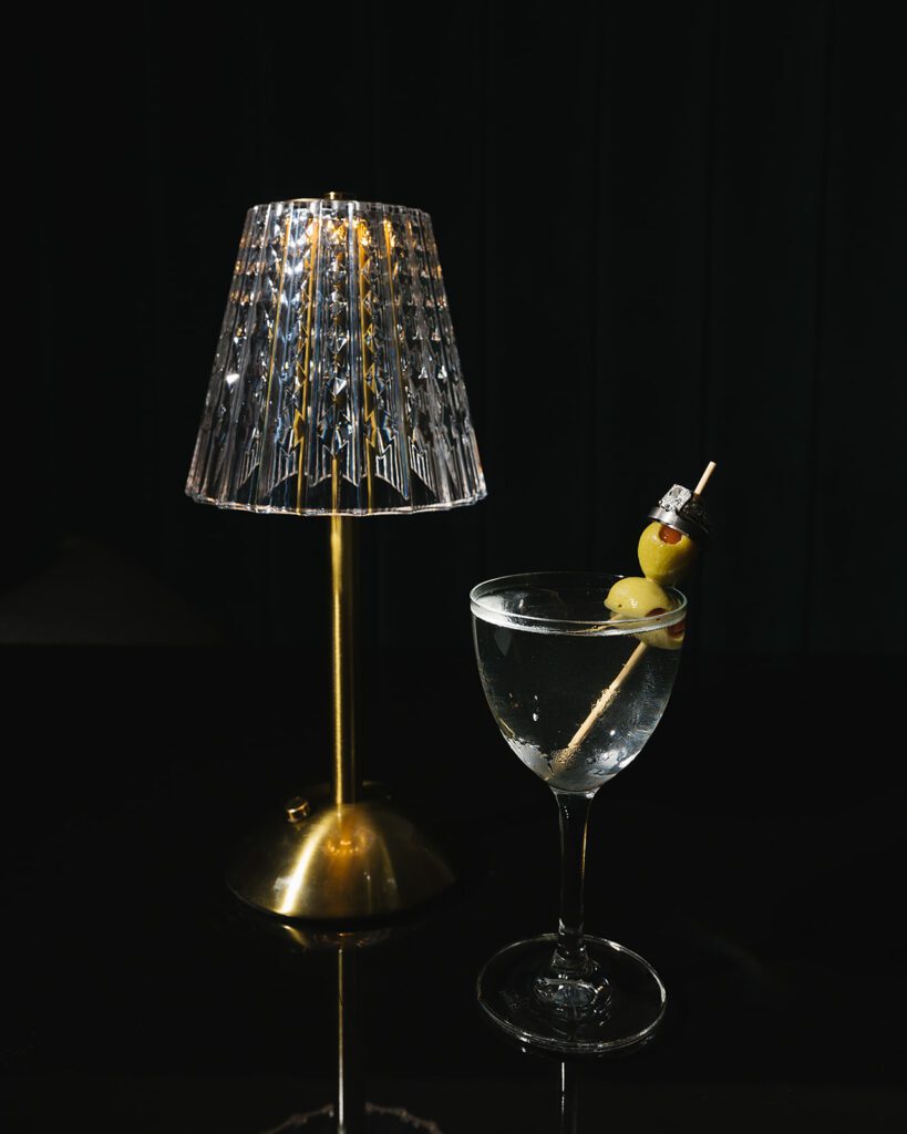 Wedding reception detail shot with a martini next to a lamp