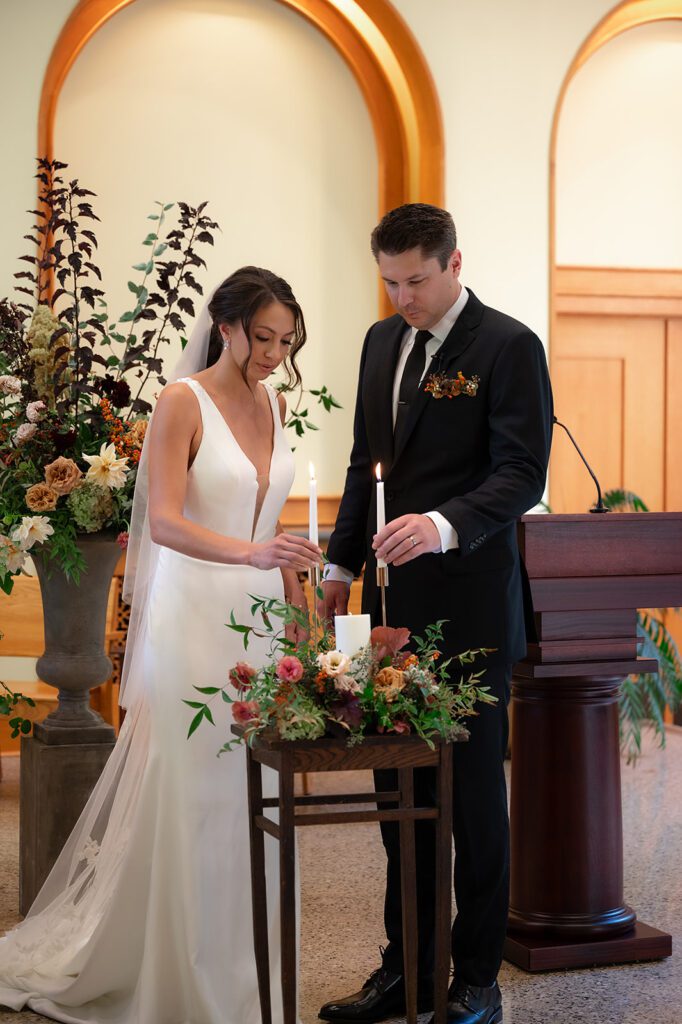 Bride and groom lighting a candle during their Grand Rapids Wedding Ceremony at Our Lady Seat of Wisdom Chapel on Aquinis College