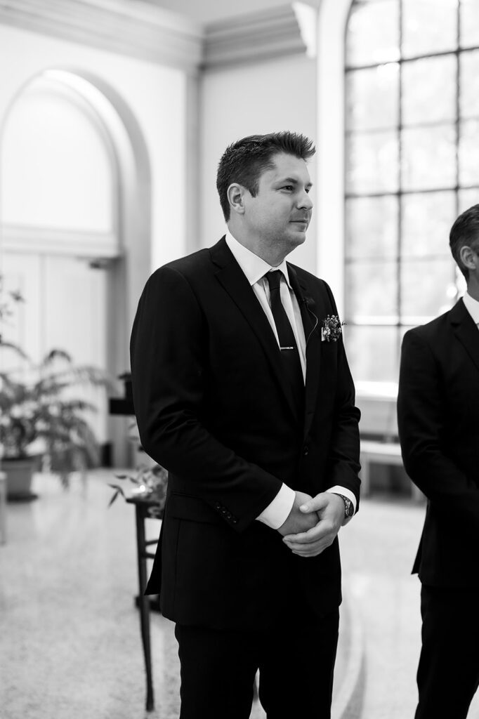 Groom watching his bride walk down the aisle