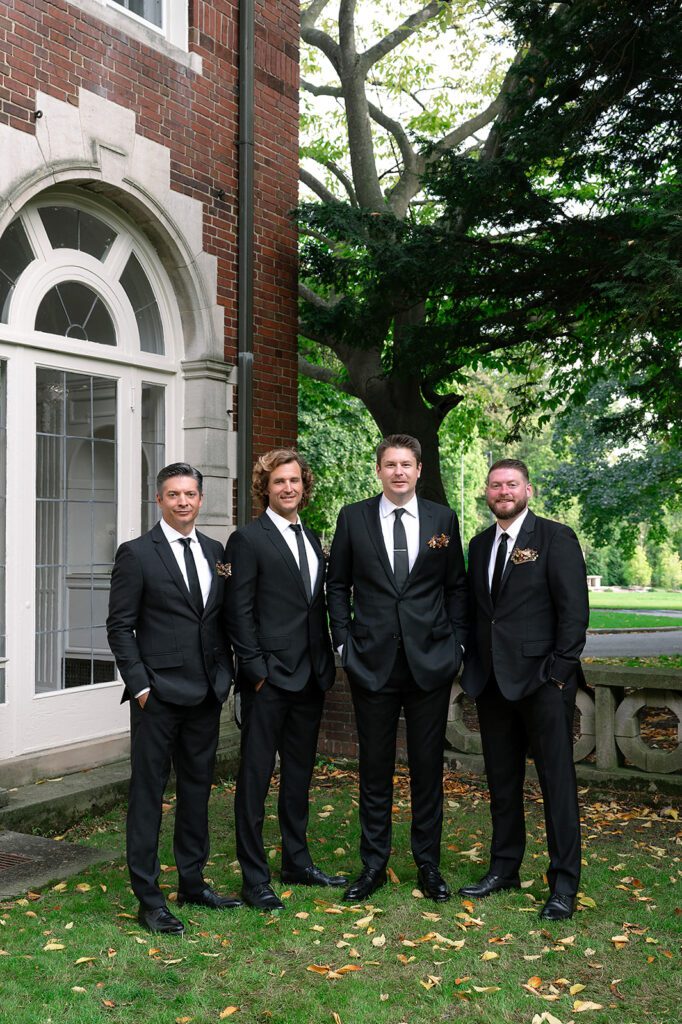 Outdoor groom and groomsmen photo at Holmdene Hall at Aquinas College