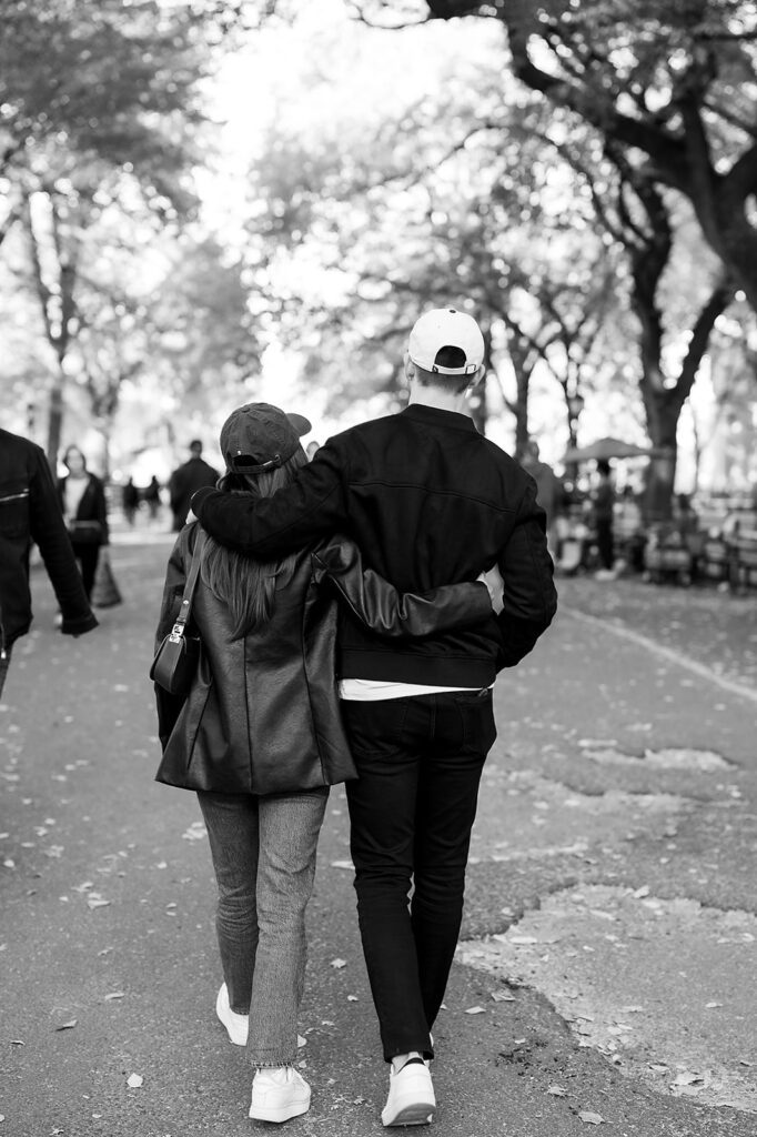 Black and white photo of a couple walking down The Mall in Central Park.