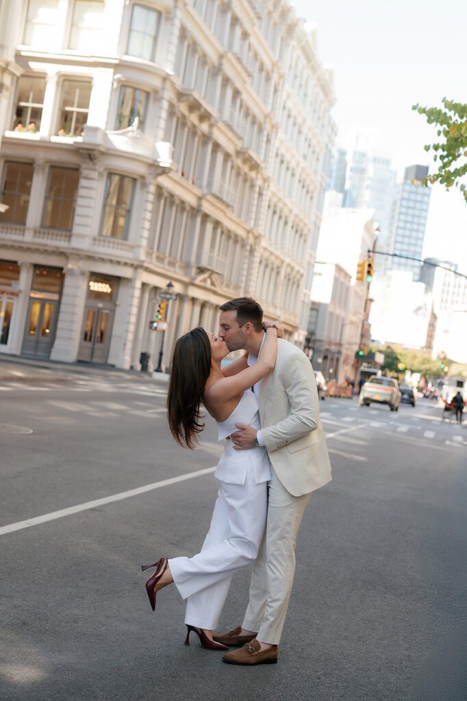 Couple kissing in the middle of a New York street with SoHo buildings in the background.