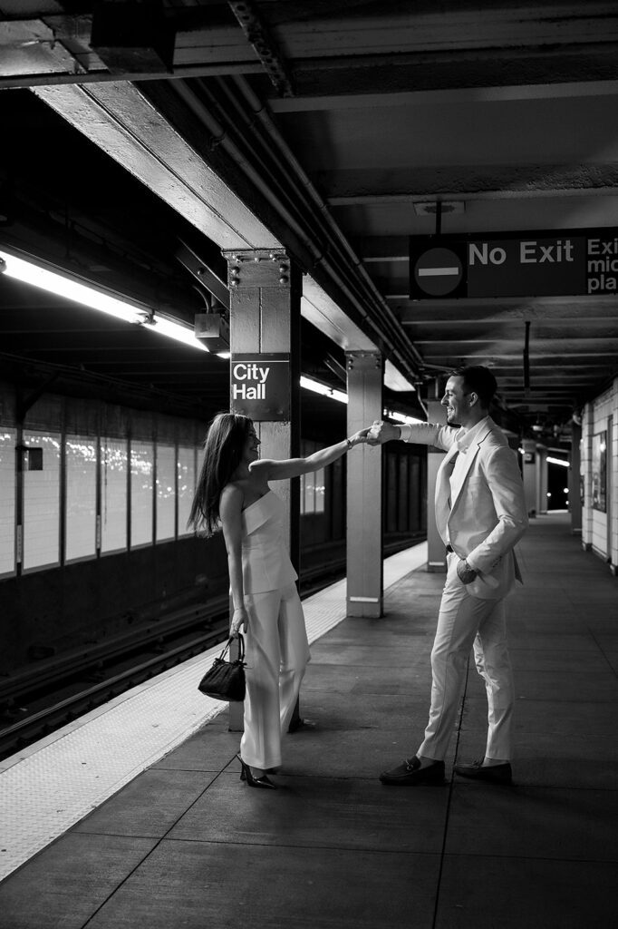 Black and white photo of couple dancing on City Hall subway platform.