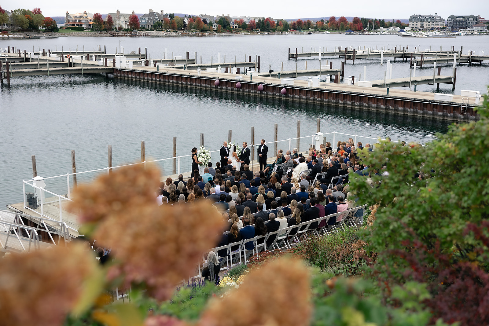Wide view of the Bay Harbor Yacht Club Promenade Dock ceremony with guests seated along the water.