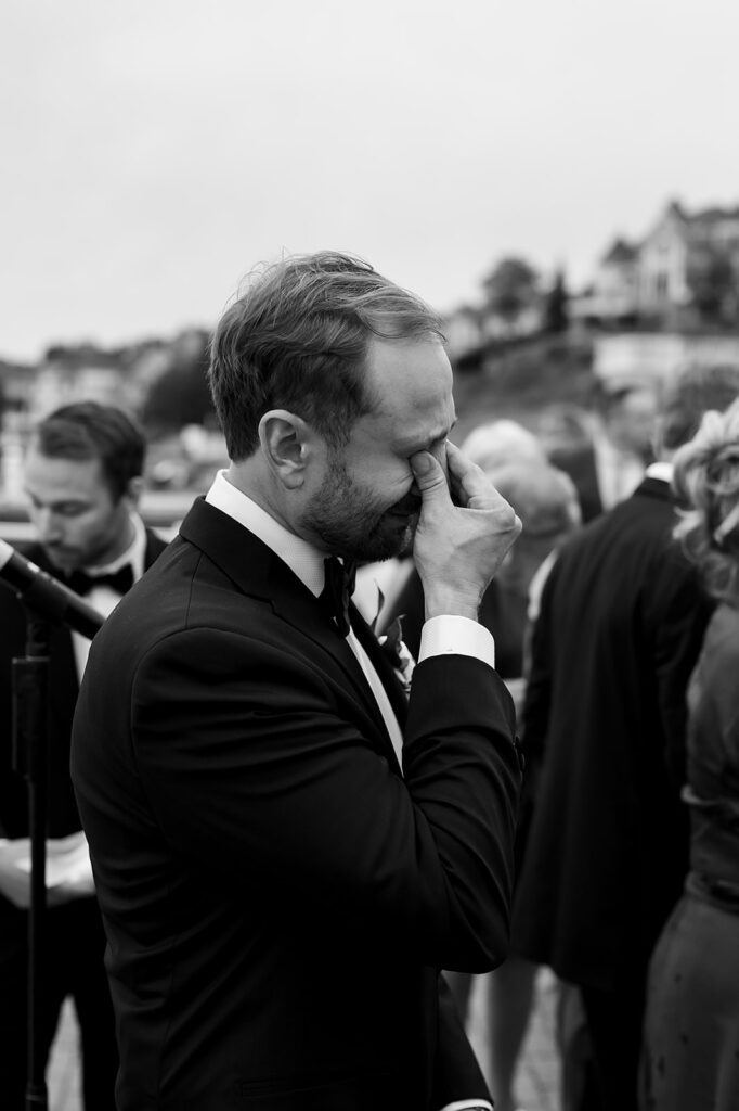 Groom wiping tears during the Bay Harbor Yacht Club ceremony.