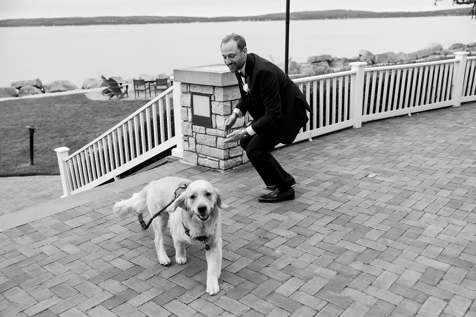 Black and white photo of a groom and his dog having a moment before the first look