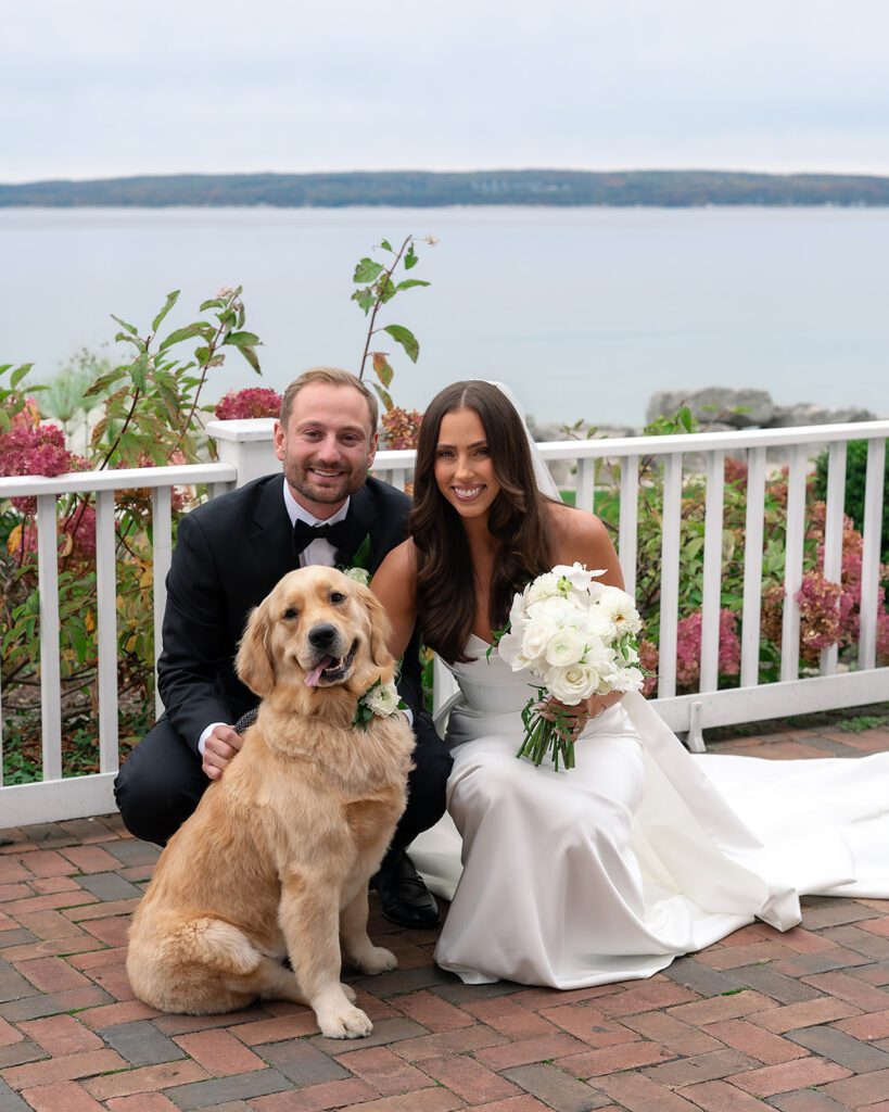 Bride and groom posing with their dog on the terrace at Bay Harbor Yacht Club.