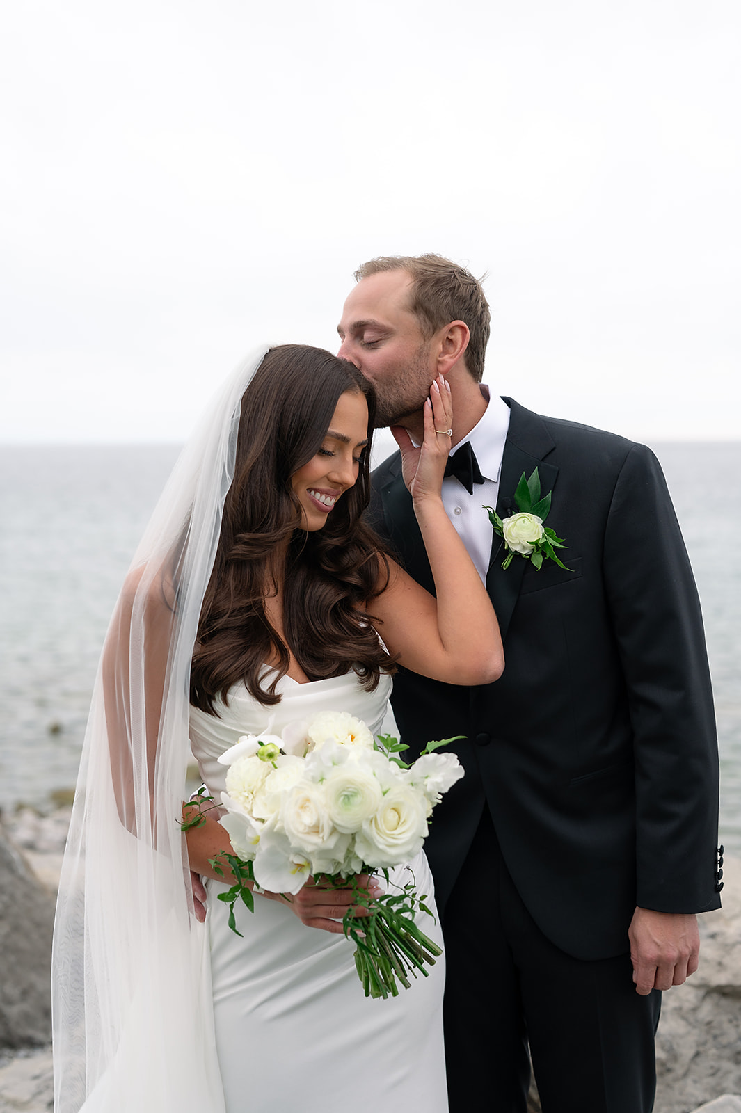 Bride and groom posing with Little Traverse Bay in the background
