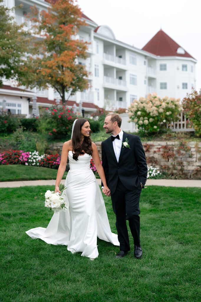Bride and groom holding hands and walking in front of Bay Harbor Yacht Club