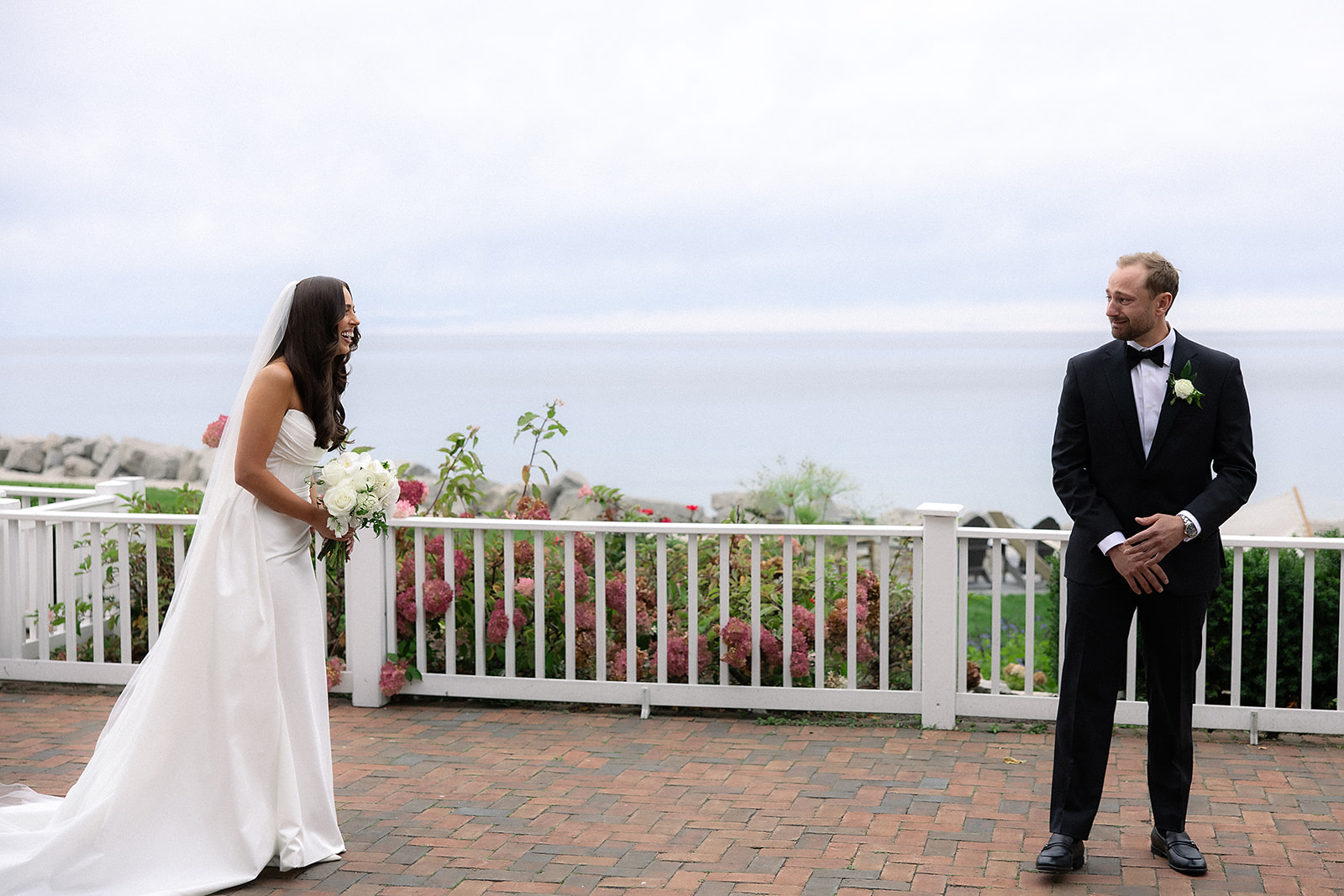 Bride and groom sharing their first look on the terrace at Bay Harbor Yacht Club with the bay in the background.