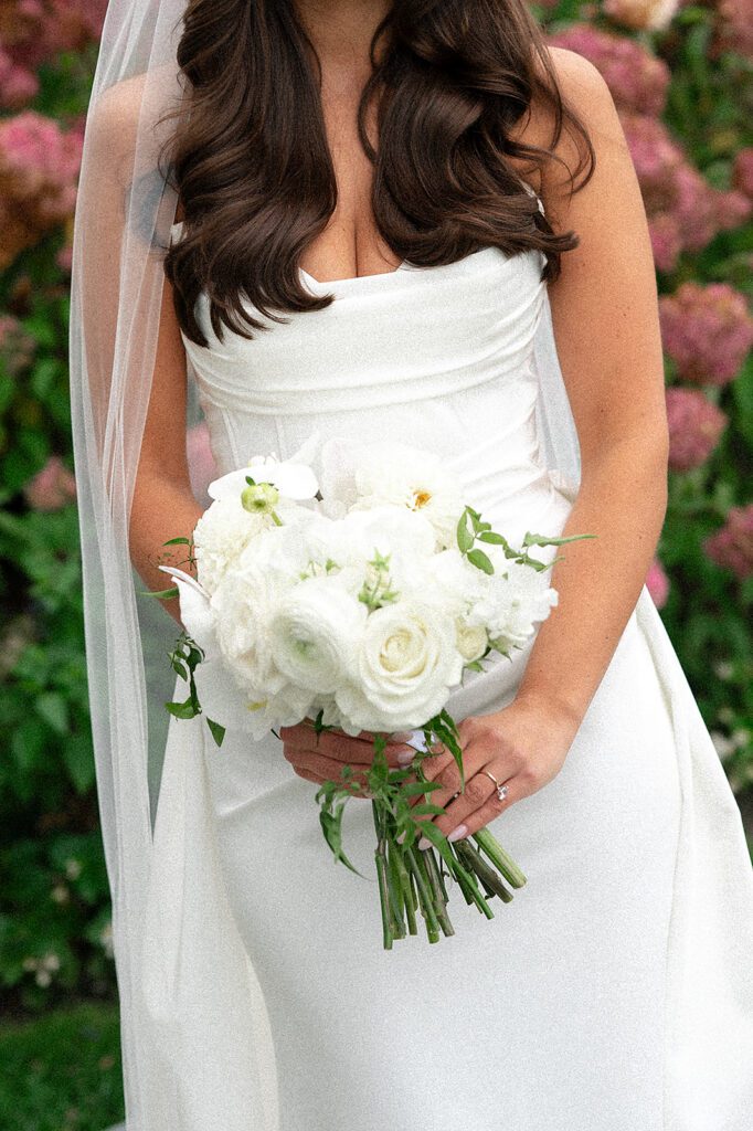 Close up shot of a bride holding her classic white bouquet by Sweetwater Floral