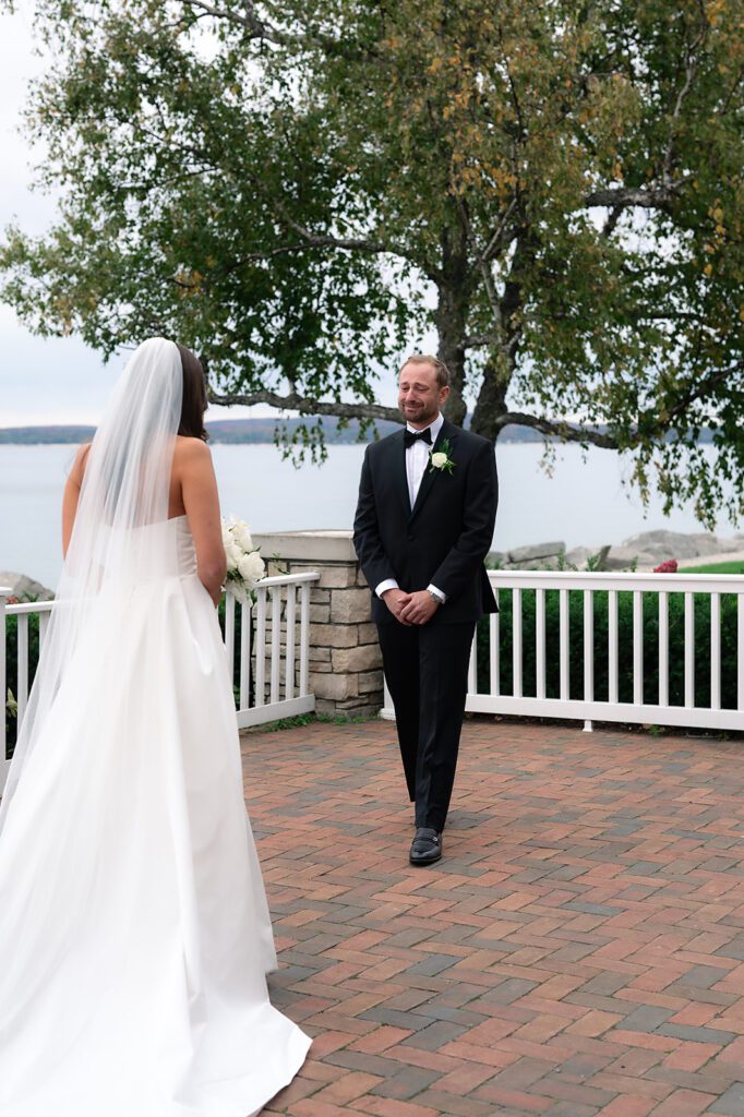 Bride and groom sharing their first look on the terrace at Bay Harbor Yacht Club with the bay in the background.