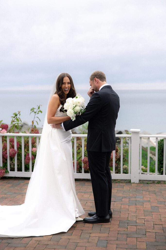 Groom wiping tears during emotional first look with the bride before the ceremony.