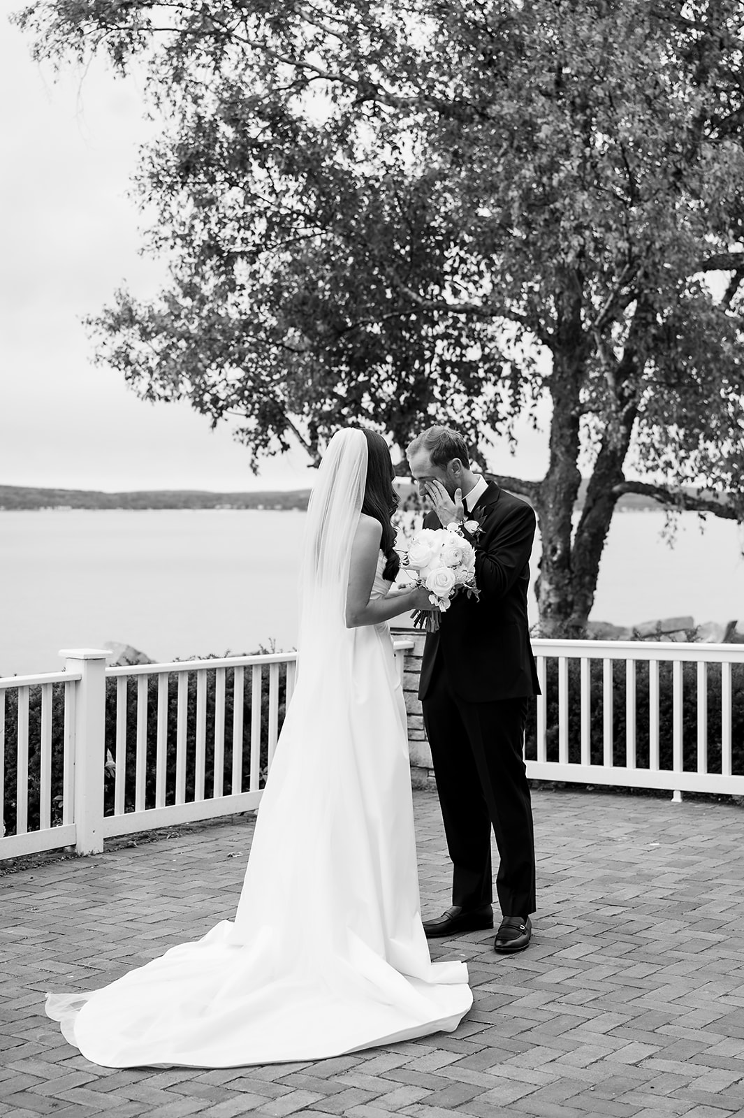 Groom wiping tears during emotional first look with the bride before the ceremony.