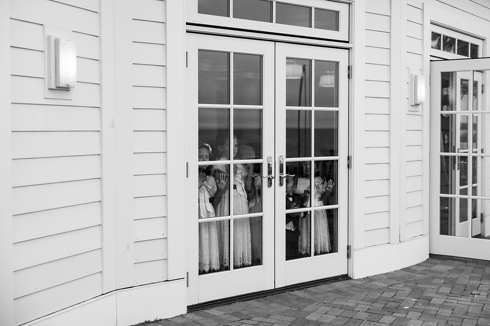 Kids watching through the window as portraits are being taken outdoors