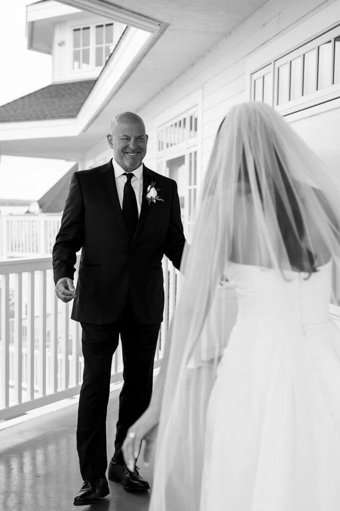 Father seeing the bride for the first time during an emotional first look on the balcony.