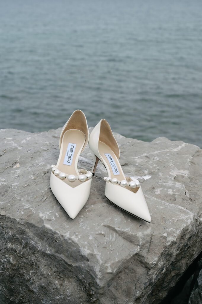 Wedding detail shot of the brides heels on the rocks of the Little Traverse Bay